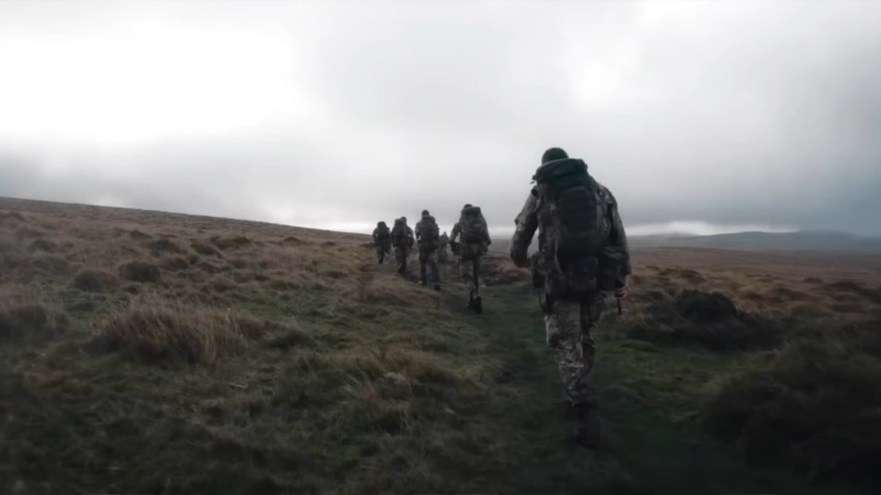 A Group of Soldiers Hikes up A Grassy Hill in Rugged Terrain, Preparing for The Endurance Challenges Outlined in A 12-Week Military Running Program