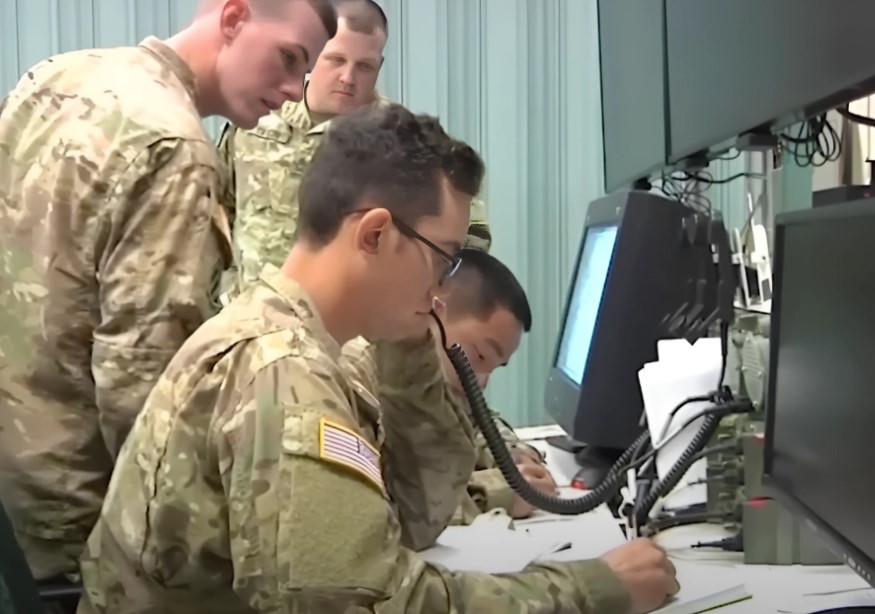 Signal corps soldiers looking at a radar on a monitor