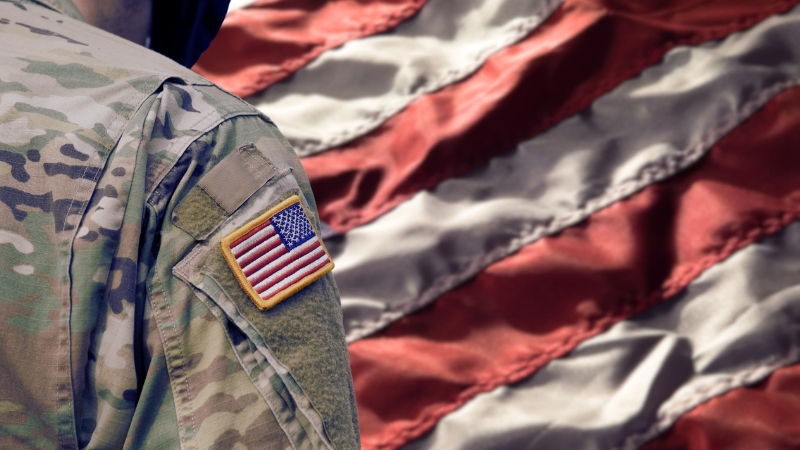 Soldier Wearing a Military Uniform with The American Flag in The Background