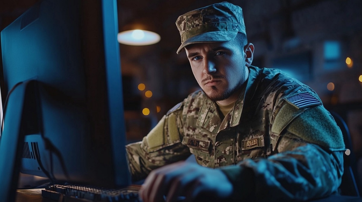 A military officer in camouflage uniform working on a computer in a dimly lit cyber warfare control room