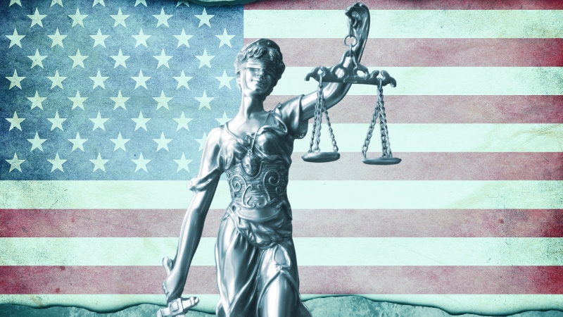 An Image of Lady Justice with Scales in Front of The American Flag