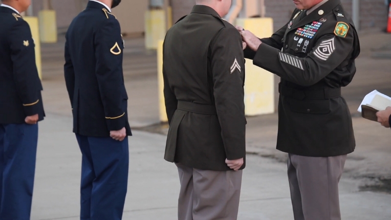 A Service Member Receiving Insignia on Their AGSU Army Uniform During a Ceremony