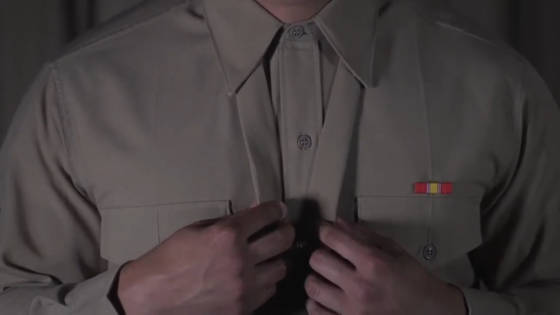 A Close-Up of A Soldier Adjusting Their Army Green Service Uniform Shirt and Neckwear