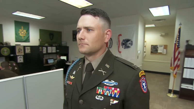 A Soldier in Full AGSU Army Uniform, Standing Attentively in An Office Setting