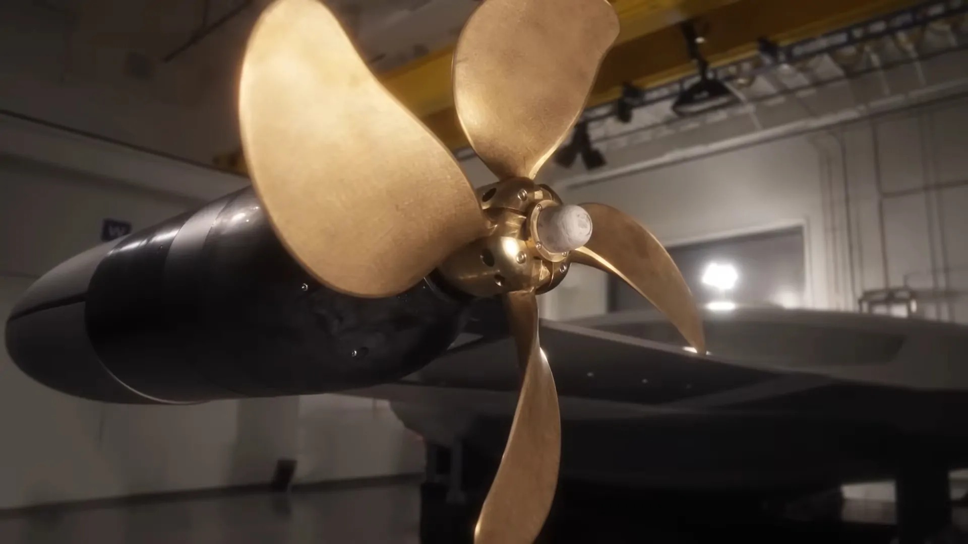 Close-up of a golden propeller attached to an underwater drone in a high-tech facility