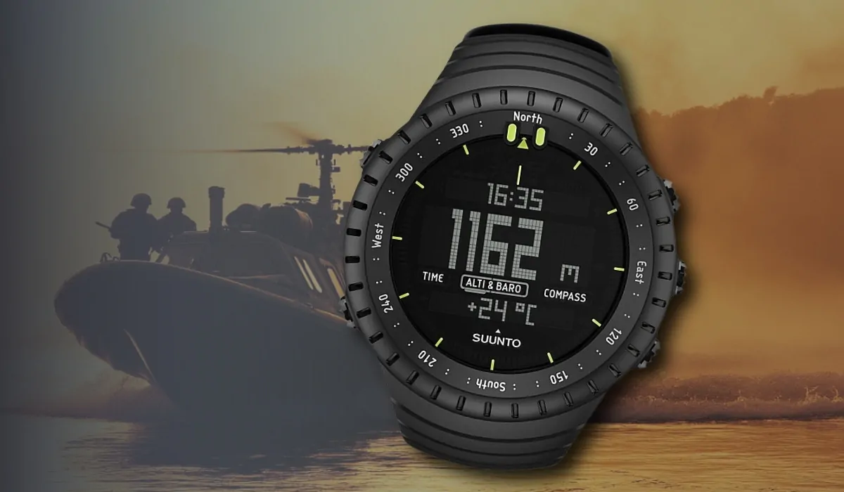 A Suunto Core digital tactical watch displaying altitude, compass, and barometer, set against a military boat and helicopter background